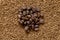 Pile of cofee seeds on instant granulated cofe background