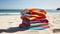 Pile of colored beach towels on the sand at the beach