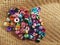 Pile of colorful aluminum beads on brown jute woven