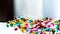 Pile of colorful antibiotic capsule pills on blur plastic drug bottle. Antibiotic drug resistance. Antibiotic drug overuse.