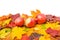 A pile of colorful autumn maple leaves and three bulk apples