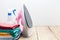 Pile of colorful clothes and irons,spray bottles on wooden plank