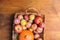 Pile of colorful freshly picked plums Mirabelles red yellow green apples pumpkin in wicker basket on wood garden table. Autumn