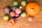 Pile of colorful freshly picked plums Mirabelles red yellow green apples pumpkin on wood garden table. Autumn fall harvest