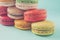 Pile of colorful macaroons stacked up like a tower in turquose pastel background (Selective focus) - Closeup.