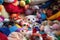 pile of colorful plush toys with a ferret peeking out