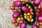 Pile of colourful foil wrapped chocolate easter eggs in pink, red, silver and gold with two halves of a large dark chocolate eggs.