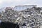 A pile of concrete debris on the background of residential buildings of the city