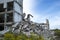 A pile of concrete debris with the remains of a large building against the blue sky. Background. Text space