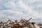 A pile of concrete fragments of a destroyed building against the sky with gray clouds. Background