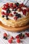 Pile of crepes with berries close-up on a plate. Vertical