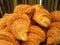 Pile of croissants in on shelf in bakery or baker`s shop