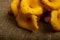 A pile of curly cookies in the form of chanterelle mushrooms on a homespun fabric with a rough texture. Close up