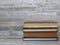 A pile of different coloured old books on bleached and whitewash beech wood background.