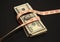 A pile of dollars with tape measure background