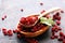 Pile of dry barberries in a wooden bowl on rustic table