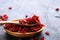 Pile of dry barberries in a wooden bowl on rustic table