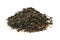 Pile of dry green gunpowder tea.  Heap of green tea leaves with safflower flower petals on white