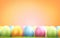 Pile of Easter eggs with green blades of green at orange blurred