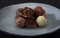 A pile of exquisitely beautiful chocolate cubes placed on a dark blue ceramic plate with parallel stripes.