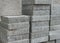 Pile of flat gray square pavement bricks