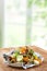 A pile of food waste, such as eggshells and fruit and vegetable peels, on a paper and wooden table kitchen background