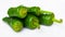 Pile of fresh green padron peppers on white background