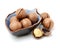 Pile of fresh macadamia nuts rich in nutrients with some whole shelled nuts, some nuts still in their shells and a few halved with