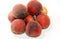 pile of fresh peach fruit isolated on white background, selective focus of a stack of ripe bright peaches, healthy fresh food