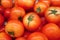 Pile of fresh ripe vibrant red tomatoes at the market