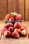 Pile of fresh strawberries with spot focus on isolated wooden background