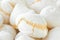 Pile of freshly backed homemade meringue cookies at farmers market. Artisan local pastry. Creamy texture pastel colors. French