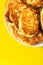 Pile of freshly fried homemade fluffy pancakes from cottage cheese on plate on bright yellow background. Appetizing golden crust