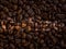 Pile of freshly roasted coffee beans background with German "Kaffee" text