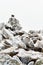 A pile of frosted stones on top of the Snieznik mountain on a hiking mountain trail, winter landscape on a foggy day