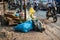 Pile of garbage bags and messy trash on street sidewalk with traffic on background in Hanoi, Vietnam