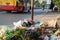 Pile of garbage bags and messy trash on street sidewalk with traffic on background in Hanoi, Vietnam