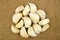 Pile of garlic cloves on a sack cloth background