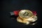 Pile of gold bitcoin cryptocurrency coins with red digital hardware wallet on dark background.