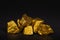 A pile of gold nuggets or gold ore on black background, precious