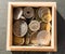 Pile of gold and silber coins in wood box on the natural background