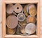 Pile of gold and silber coins in wood box on the natural background
