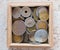 Pile of gold and silber coins in wood box on the natural background