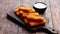 Pile of golden fried fish fingers with white garlic sauce