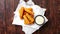 Pile of golden fried fish fingers with white garlic sauce