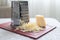 A pile of grated cheese on plastic board next to a grater