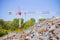 Pile of gravel, stones and pebbles of different sizes against a tower crane