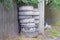 A pile of gray old car tires near a wooden fence