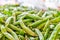 Pile of green snap peas pea pods being sold at a farmer`s market