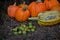 A pile of green walnuts on the ground placed next to a group of pumpkins. rich autumn harvest at the village farm